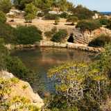 ...all�improvviso ci ritroviamo davanti a un panorama mozzafiato. Ci troviamo su un dirupo e sotto di noi si apre in tutta la sua bellezza il misterioso lago: un piccolo bacino di color verde intenso abbracciato da alte pareti rocciose e situato a pochi metri dallo sfondo azzurro del mare